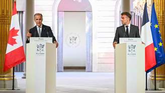 O primeiro-ministro do Canadá, Mark Carney (à esquerda), se dirige à imprensa durante uma conferência de imprensa com o presidente da França, Emmanuel Macron (à direita), antes de uma reunião bilateral no Palácio Presidencial do Eliseu, em Paris, em 12 de junho de 2026. (Foto: POOL / AFP)