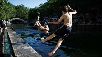 Adolescentes saltam no Canal Saint-Martin, no nordeste de Paris, em 26 de maio de 2026.