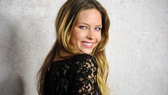 A atriz Daveigh Chase sorri enquanto olha por cima do ombro para a estreia de 2011 de sua série Big Love, da HBO. 


