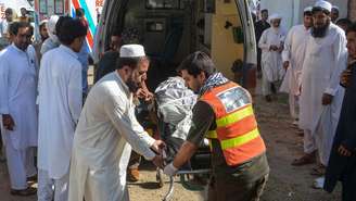 Voluntários transportam o corpo de uma vítima, morta em duas explosões em uma estrada do Paquistão. Em Bannu, em 20 de junho de 2026.
