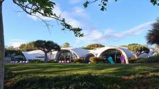 Você já ouviu falar em uma arquitetura que utiliza um balão para erguer uma casa? Pois é, ela existe e é chamada de Binishell, uma tecnologia construtiva que tem se destacado pelo mundo por unir inovação, velocidade e sustentabilidade em um único método. A Binishell foi criada na década de 1960 pelo arquiteto italiano Dante Bini, nascido em 1932, e consiste na utilização de uma membrana inflável de neoprene como molde para estruturas de concreto em formato de cúpula, um conceito simples e engenhoso que mudou a maneira de pensar a construção civil.