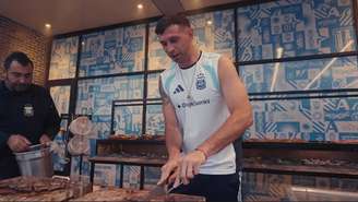 Dibu Martínez fazendo o famoso "asado argentino" na concentração da Copa de 2026.
