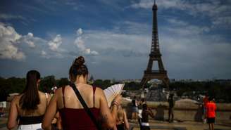 Uma mulher com um leque na Praça du Trocadéro, perto da Torre Eiffel, enquanto as temperaturas aumentam em Paris durante uma segunda onda de calor que afeta grande parte da França, em 20 de junho de 2026.