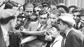 Mensageiros de corretoras se aglomeram em torno de um jornal após a primeira quebra da bolsa de valores de Wall Street, em 24 de outubro de 1929