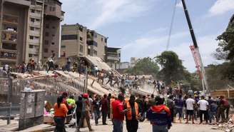 Pessoas buscam por vítimas entre os escombros de um prédio que desabou, após terremotos em Caracas, Venezuela, em 25 de junho de 2026.