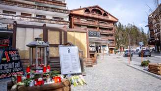 Velas e flores deixadas em frente ao bar Le Constellation, em Crans-Montana, na Suíça