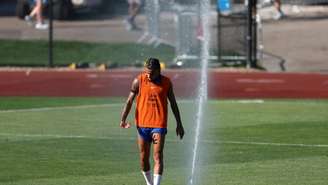 O defensor francês Malo Gusto passa por um irrigador durante um treino na Bentley University, em Waltham, perto de Boston, em 1º de julho de 2026, durante a Copa do Mundo de 2026.