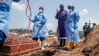 Padre e membros da Cruz Vermelha no sepultamento de um órfão que morreu de Ebola, em Bunia, no nordeste da República Democrática do Congo.