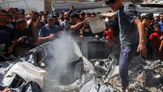 Palestinos inspecionam o local de um ataque israelense contra um veículo na Cidade de Gaza, em 9 de julho de 2026.