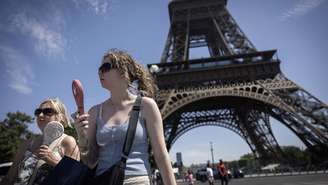 Mulheres usam ventiladores para se refrescar durante uma onda de calor em Paris, em 10 de julho de 2026.