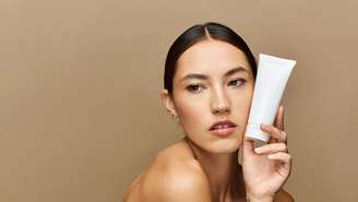 Modelo segurando produto de skincare