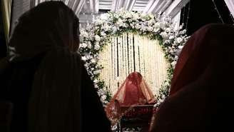 Esta foto, tirada em 3 de junho de 2026, mostra uma noiva caxemiriana sentada dentro de uma tenda decorada durante seu casamento em Srinagar.