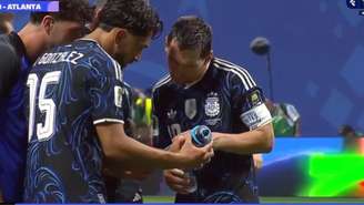 Messi e companheiros da seleção argentina observam anotações na garrafa do goleiro da Inglaterra