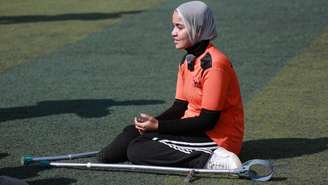 Uma jovem palestina amputada aguarda para disputar uma partida de futebol no âmbito do “Torneio da Esperança”, organizado pela associação Deniz Feneri e pela Associação Palestina de Futebol para Amputados em Deir al-Balah, no centro da Faixa de Gaza, em 17 de novembro de 2025.
