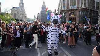 Manifestantes, incluindo um vestido de zebra, marcham nas proximidades da Ponte Erzsébet (Ponte Elisabeth), no centro de Budapeste, em 22 de abril de 2025.