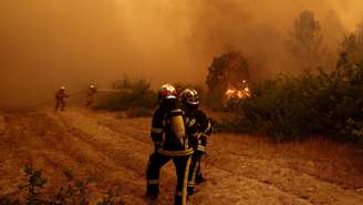 Bombeiros tentam controlar as chamas durante um incêndio florestal em Lège‑Cap‑Ferret, no departamento da Gironda, em 24 de julho de 2026.