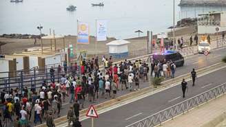 Policiais espanhóis escoltam um grande grupo de migrantes até a fronteira para retirá‑los da Espanha, após travessias em massa de migrantes a pé e pelo mar vindos do Marrocos para o território espanhol, em Ceuta, Espanha, em 1º de agosto de 2026.