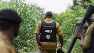 Agentes de combate ao narcotráfico inspecionam o local de um suposto laboratório de drogas ilícitas em uma área de mata densa no oeste da Nigéria