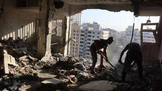 Palestinos tentam resgatar o que podem de um apartamento atingido por ataques aéreos israelenses durante a noite na cidade de Gaza, em 2 de agosto de 2026.