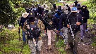 Varios hombres con armas, equipo táctico y rostros cubiertos