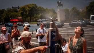 Pessoas se refrescam perto de uma fonte na Praça do Trocadéro, em Paris, durante onda de calor em 26 de junho de 2026.