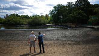 Pessoas observam o leito seco de um lago perto de Wanstead, no leste de Londres, em 10 de agosto de 2026.