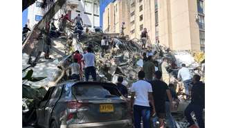 Moradores vasculham os escombros de um prédio que desabou após um terremoto, em Cali, na Colômbia - 10 de agosto de 2026