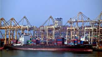 Navios atracados ao longo de um cais do terminal de contêineres de Khor Fakkan, o único porto natural de águas profundas da região e um dos principais portos de contêineres do emirado de Sharjah, localizado às margens do Golfo de Omã.