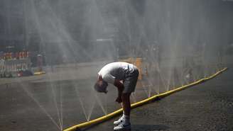 Homem molha a cabeça com mangueira instalada em rua de Colônia, no oeste da Alemanha, para combater a onda de calor. (Imagem ilustrativa)