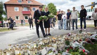 O primeiro-ministro sueco Ulf Kristersson e a líder do Partido Social-Democrata, Magdalena Andersson, visitam um memorial improvisado em frente a uma escola em Fagersta, na Suécia, em 22 de agosto de 2026, um dia após um homem armado com uma espada ter matado uma pessoa e ferido outras três na escola.