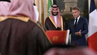 O presidente francês Emmanuel Macron e o príncipe herdeiro saudita Mohammed bin Salman durante a cerimônia de assinatura de um acordo comercial, ao final do encontro entre os dois líderes no Palácio do Eliseu, em Paris, em 24 de agosto de 2026.