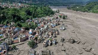 Casas encontram-se parcialmente submersas em águas barrentas à beira de um rio após inundações repentinas em Trishuli Bazar, no distrito de Nuwakot, no Nepal