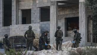 Soldados israelenses removem o corpo de um palestino morto de uma casa em construção, nos arredores da cidade de Jenin, no norte da Cisjordânia ocupada por Israel, em 28 de agosto de 2026.