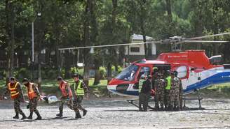 Militares do Exército carregam um morador resgatado em um acampamento militar após as enchentes repentinas, na cidade de Battar Bazar, no distrito de Nuwakot, no Nepal, em 28 de agosto de 2026.