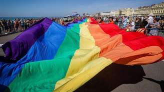 Enorme bandeira arco-íris desfraldada durante a parada do orgulho gay de Brighton, na Inglaterra, em 2022