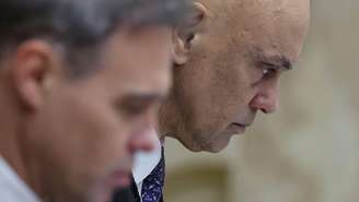 Imagem mostra os ministros Alexandre de Moraes e André Mendonça de perfil. Mendonça aparece à frente de Moraes, ambos no Plenário do STF