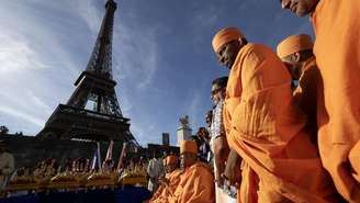 Membros do movimento espiritual hindu Bochasanwasi Akshar Purushottam Swaminarayan Sanstha participam de uma cerimônia religiosa em frente à Torre Eiffel, em Paris.