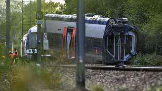 Funcionários da SNCF, a companhia de trens francesa, intervêm perto de um vagão descarrilado em Cléon, no noroeste da França, em 12 de setembro de 2026, um dia após o descarrilamento.