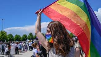 Integrante da comunidade lésbica, gay, bissexual, transgênero queer, intersexo e assexual (LGBTQIA+) segura uma bandeira do arco‑íris, símbolo da comunidade, durante um protesto contra a retirada da Turquia da Convenção de Istambul, em 19 de junho de 2021.