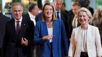 Mark Carney (à esquerda) caminha ao lado da presidente do Parlamento Europeu, Roberta Metsola (ao centro), e da presidente da Comissão Europeia, Ursula von der Leyen (à direita)