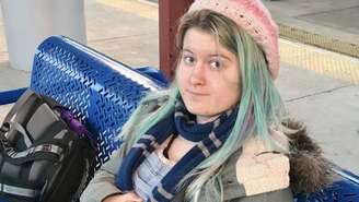 Emily Normandin-Parker está sentada em um banco.