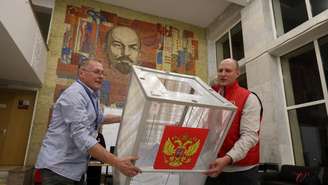 Membros de uma comissão eleitoral local esvaziam uma urna antes da apuração dos votos em um centro cultural adornado com um mosaico de Lênin, em Podolsk, nos arredores de Moscou, em 20 de setembro de 2026.