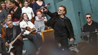Adam Clayton, Bono e Larry Mullen Jr. se apresentam no palco enquanto o U2 celebra seu 50º aniversário ao voltar à Mount Temple Comprehensive School, em setembro de 2026