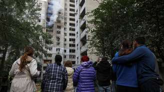 Pessoas se reúnem no local onde um prédio residencial foi atingido por um ataque de drone russo, em meio à ofensiva da Rússia contra a Ucrânia, em Kiev, em 25 de setembro de 2026.