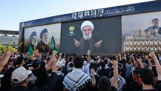 Apoiadores do movimento xiita libanês Hezbollah gritam palavras de ordem enquanto assistem a um discurso televisionado do líder do grupo, Naïm Qassem, durante uma cerimônia realizada para marcar o segundo aniversário da morte do ex-líder Hassan Nasrallah, morto em um ataque israelense, nos subúrbios ao sul de Beirute, em 27 de setembro de 2026.