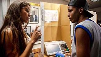 Jovens conversam em frente de urna eletronica