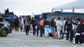 A polícia espanhola organiza a remoção de migrantes do acampamento provisório de El Guano, próximo à praia de Trampolin, no enclave espanhol de Ceuta, no norte da África, em 11 de outubro de 2026.