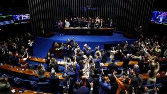 Os legisladores comemoram após votarem a favor de uma emenda constitucional para reduzir a semana de trabalho no Brasil de seis para cinco dias, durante uma sessão do Senado Federal, em Brasília, Brasil, em 14 de outubro de 2026.