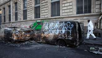 Carros incendiados em uma rua próxima à Praça da República, em Paris, neste domingo 18 de outubro de 2026.