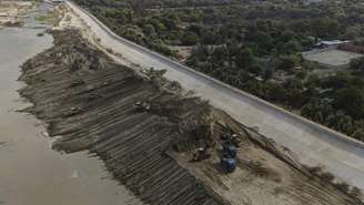 Vista aérea de um trecho do rio Piura, onde máquinas pesadas realizam trabalhos de limpeza e retirada de sedimentos nas proximidades da cidade de Piura, no Peru, em 4 de setembro de 2026. No árido norte peruano, moradores se preparam para enfrentar as enchentes associadas ao El Niño. Barreiras improvisadas bloqueiam as entradas das casas, enquanto bueiros obstruídos por detritos espalham mau cheiro pelas ruas.